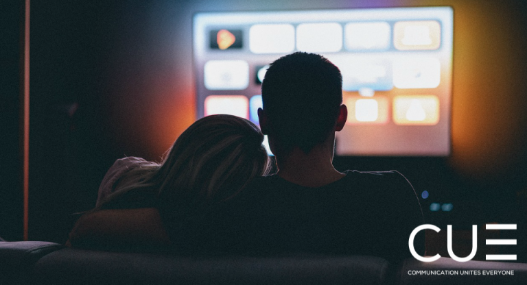 Couple watching a TV streaming service at home in the dark